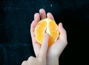 person holding sliced orange fruit