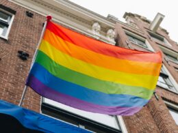 a rainbow flag is flying in front of a building