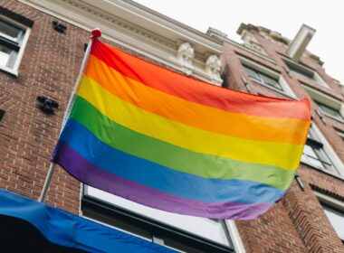 a rainbow flag is flying in front of a building